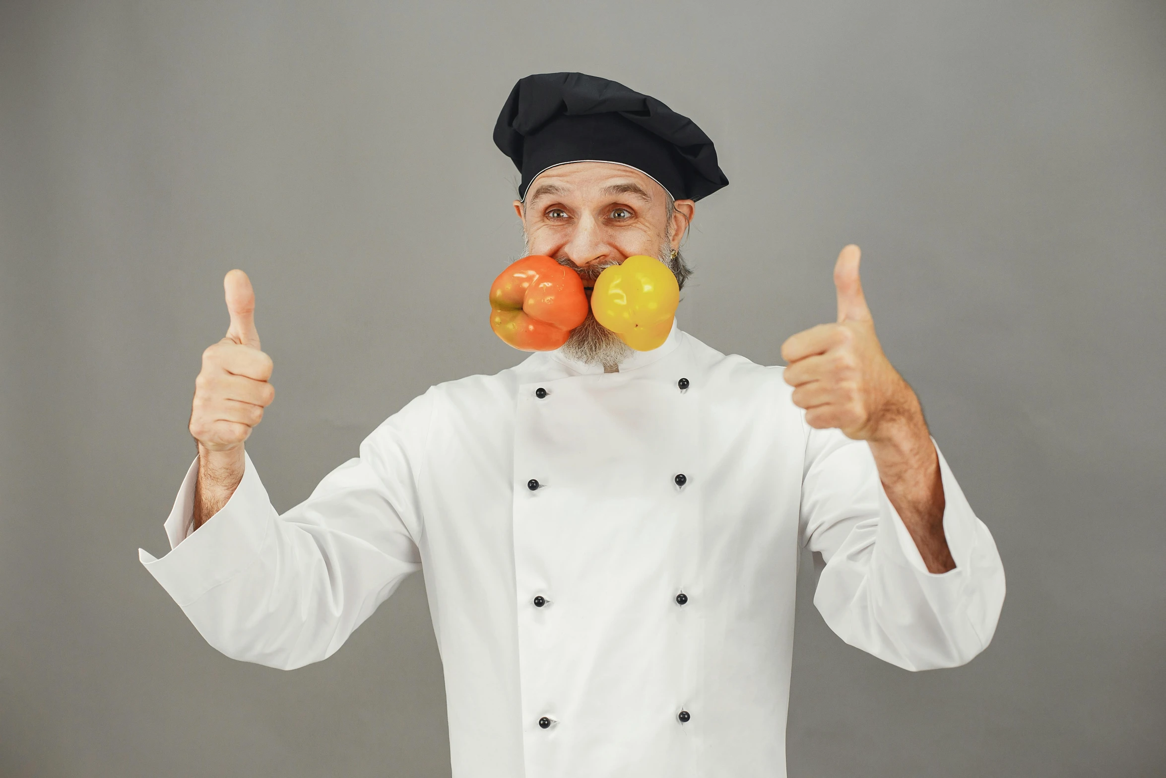 a chef is holding a few fruits up to his face