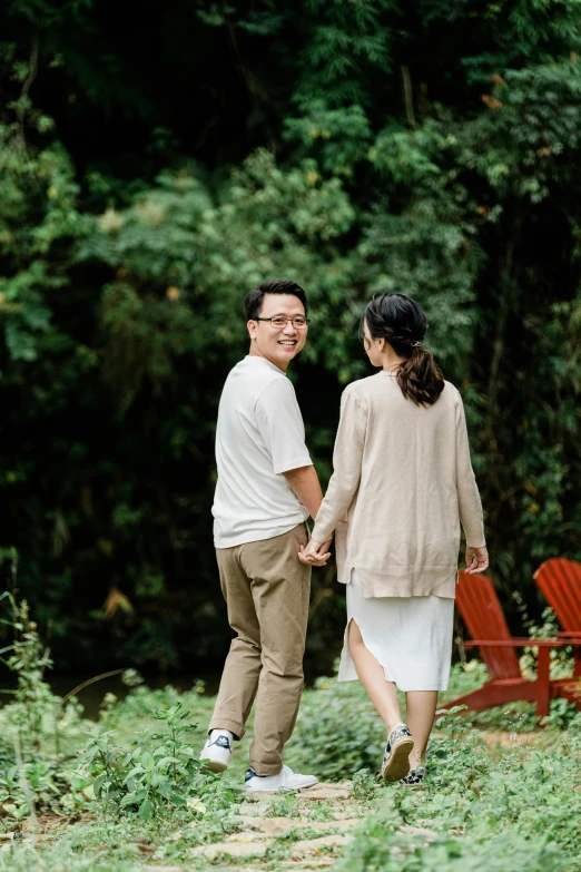 an asian couple hold hands and smile together