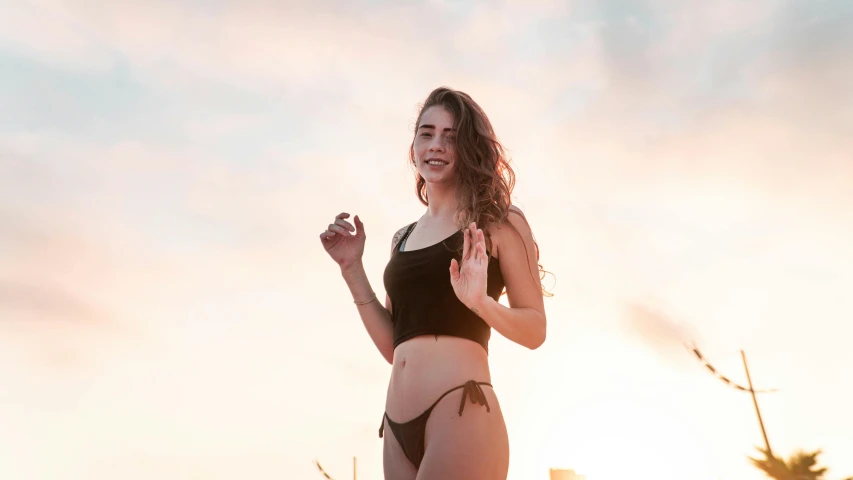 a woman wearing a black bikini bottom flying a kite