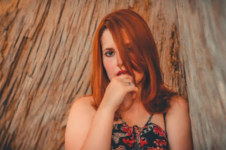 a woman is posing in front of wooden wall