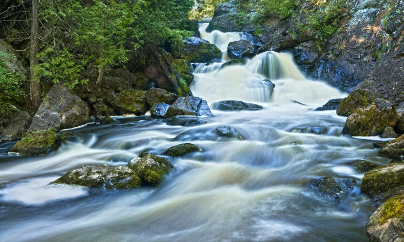 a waterfall surrounded by trees and rocks