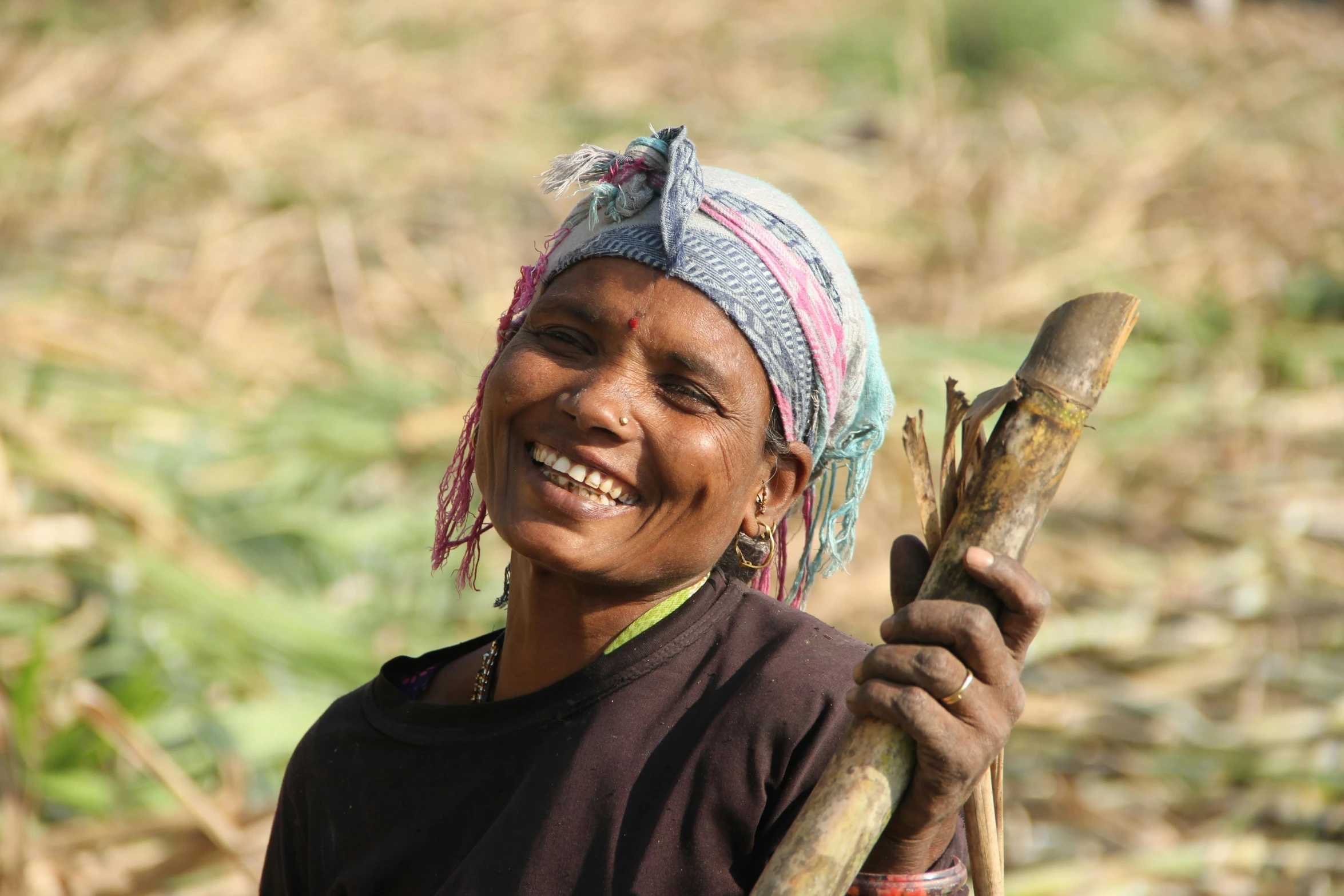 a woman with long ear hair wearing a turban holding a stick