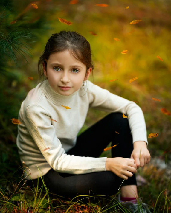 young woman sitting in the grass, staring directly into the camera