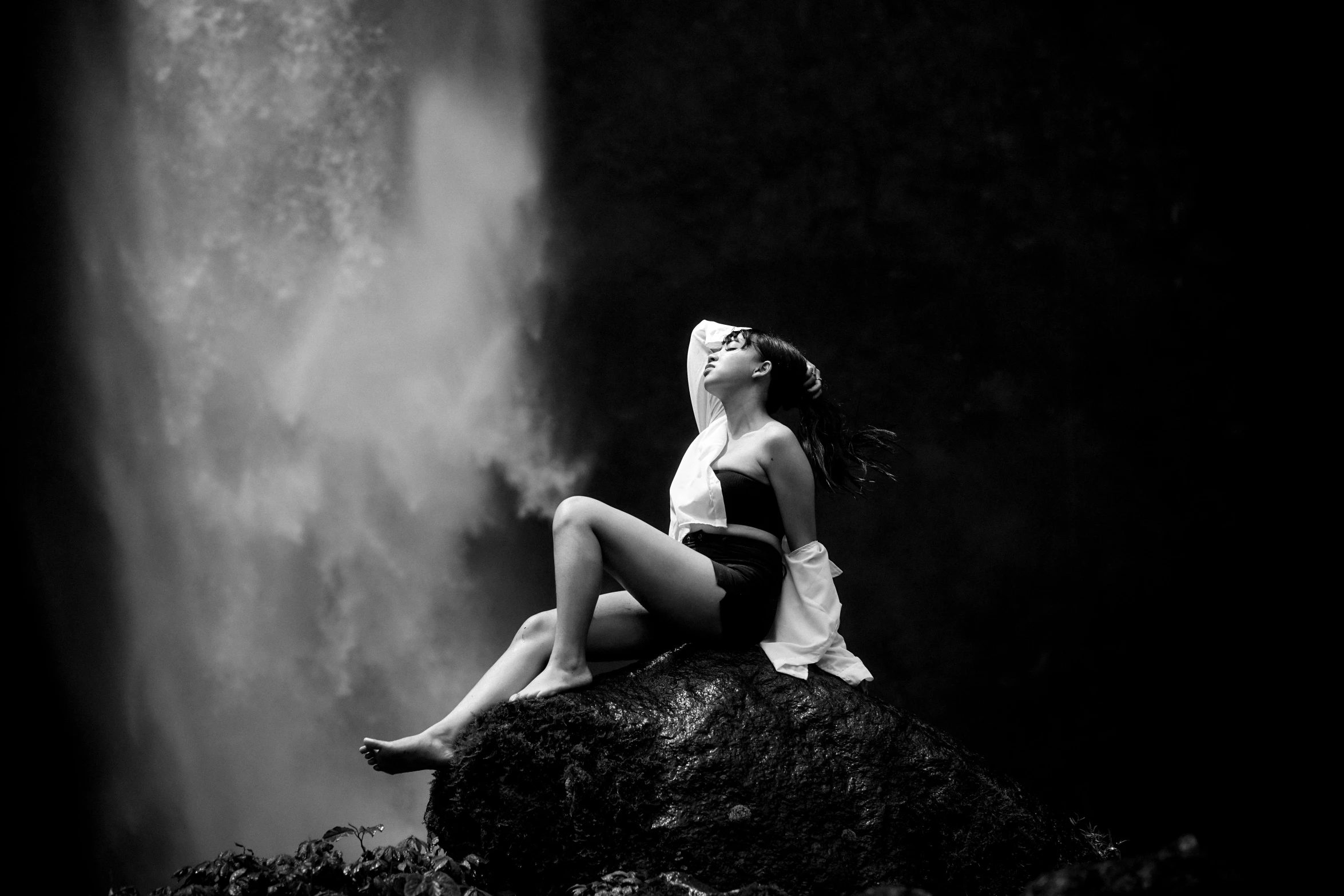 the woman sitting on top of a rock is posing for a po