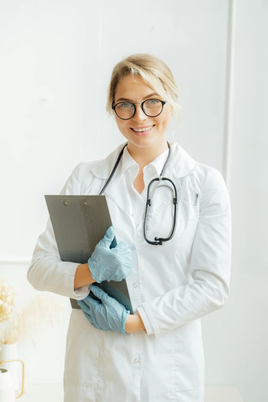 a smiling medical worker holding a laptop computer