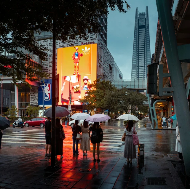 people walk across a wet sidewalk holding umbrellas