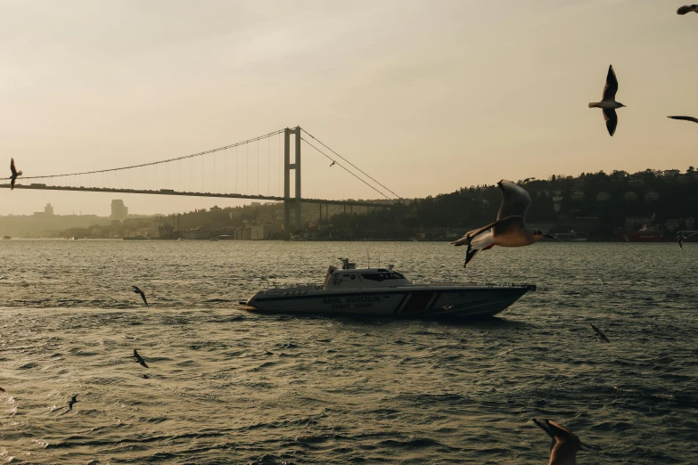 a boat traveling across a river next to a large bridge