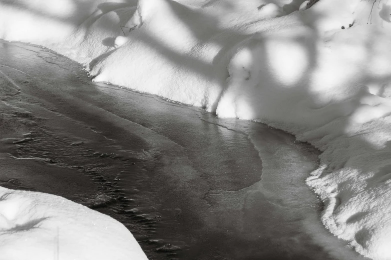 a water stream in the middle of a snow covered landscape