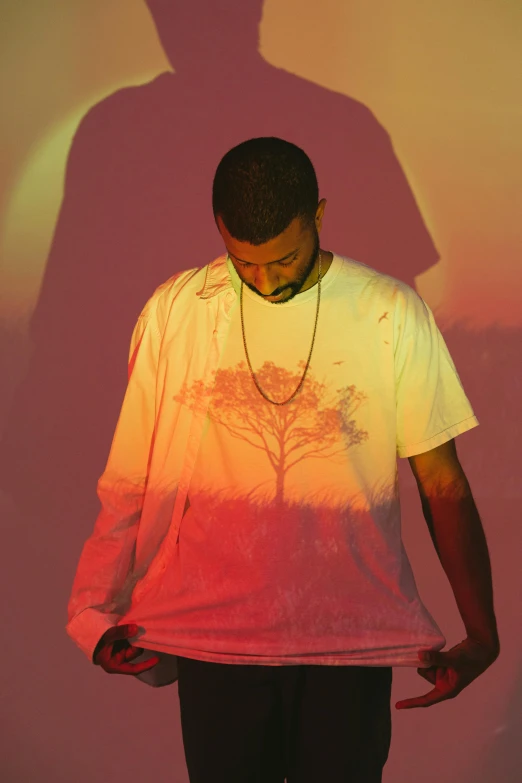 a man wearing a white shirt standing in front of a purple background with trees