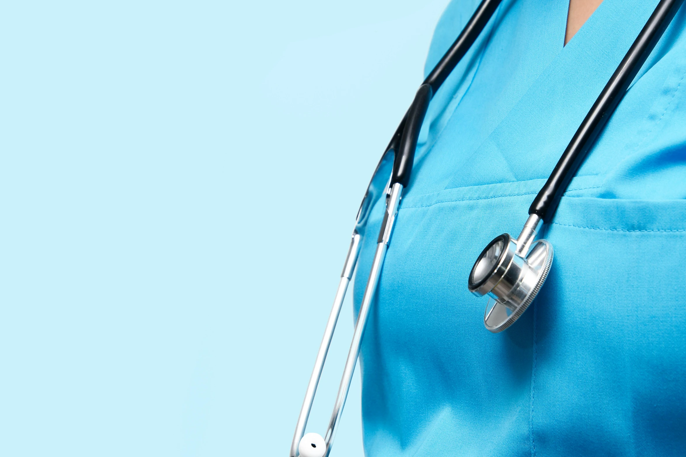 a woman wearing a blue scrubbing uniform and holding a stethoscope