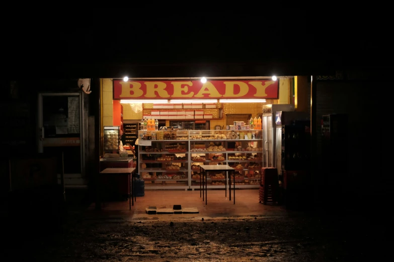 a person that is sitting down in front of a shop