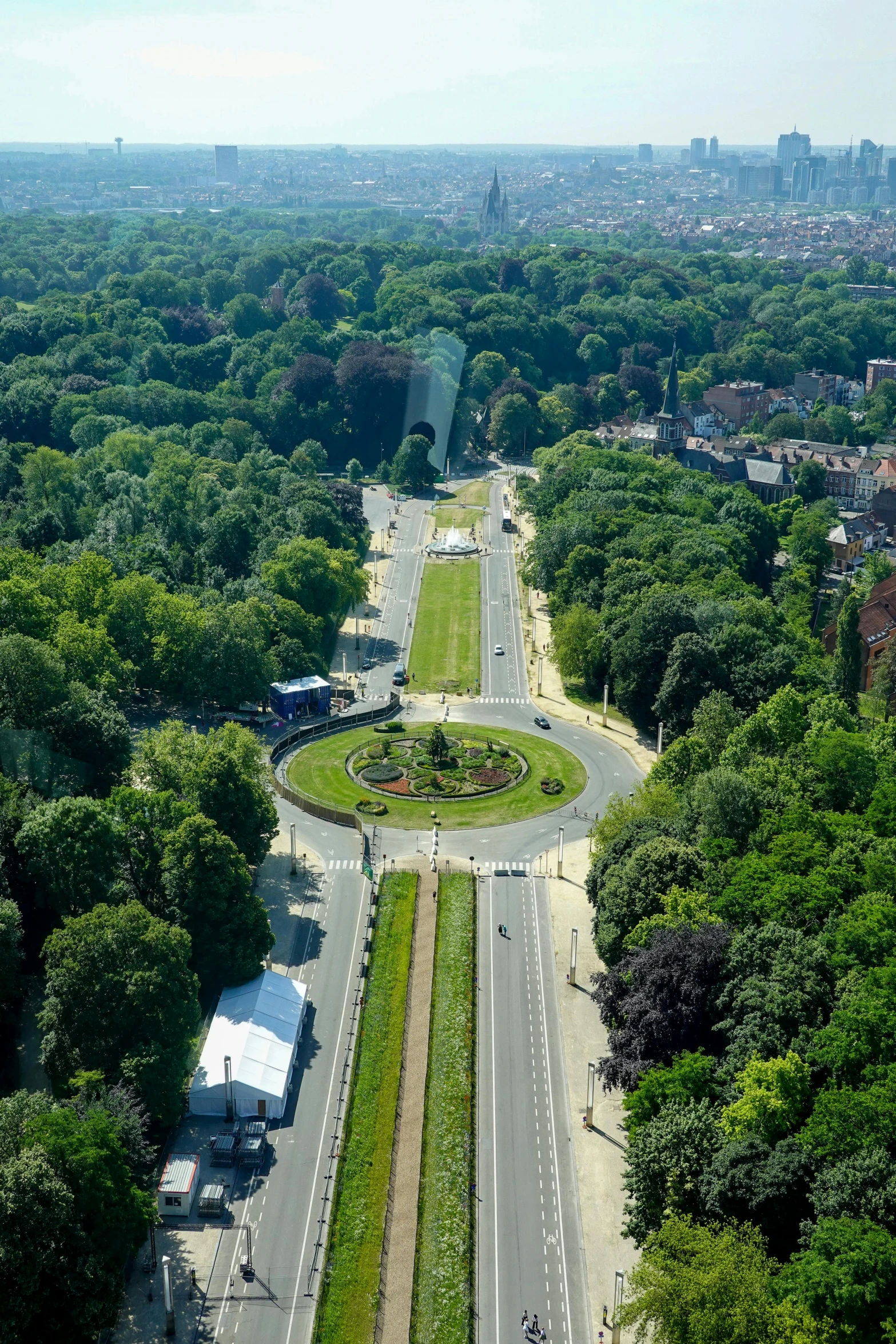 a city with a crosswalk, roadway and trees