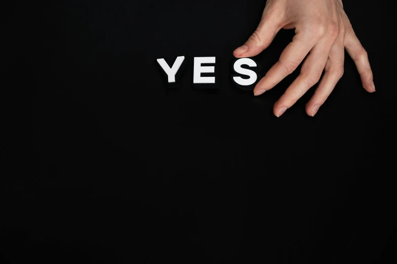 a person's hands are reaching out towards the word yes