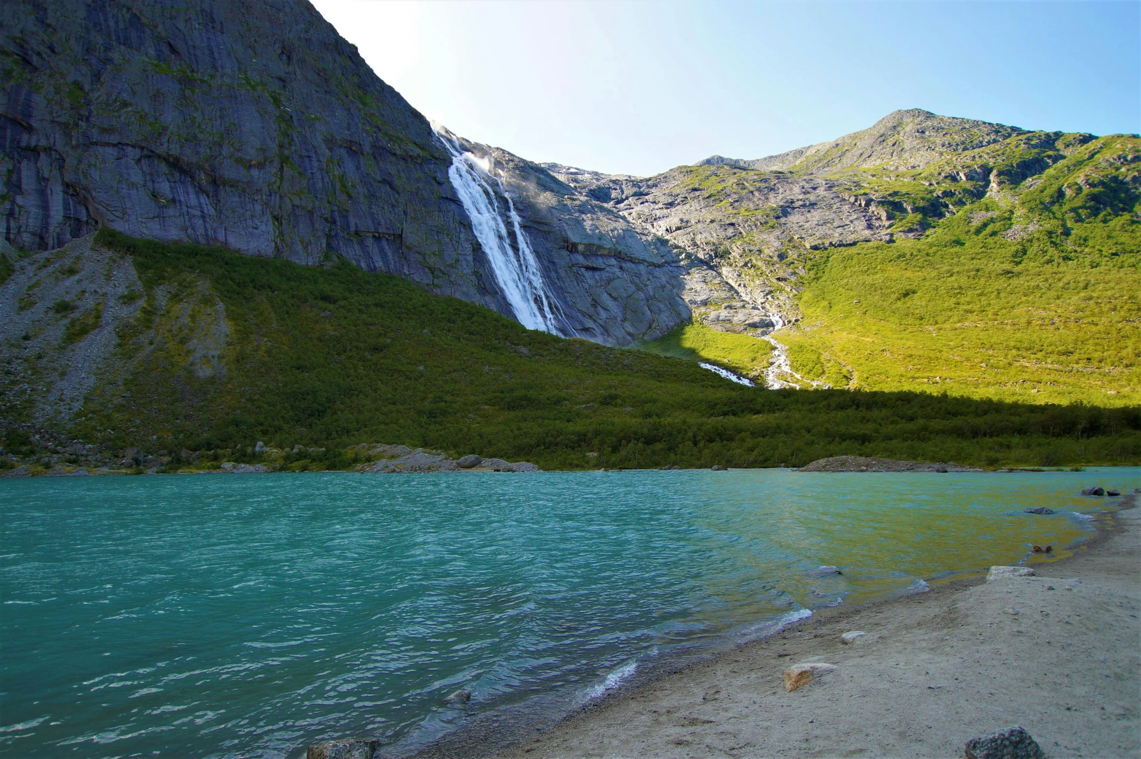 a stream is seen in front of a mountain side