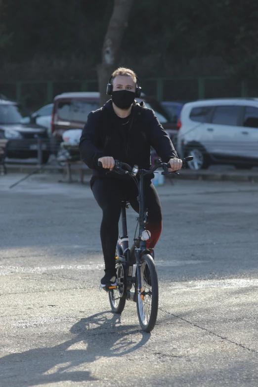 a man riding his bicycle in the parking lot