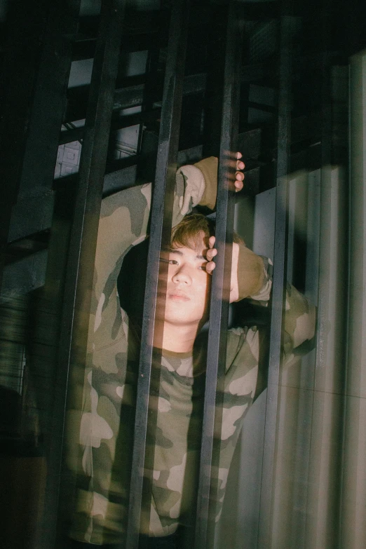 there is a boy sitting in  behind bars