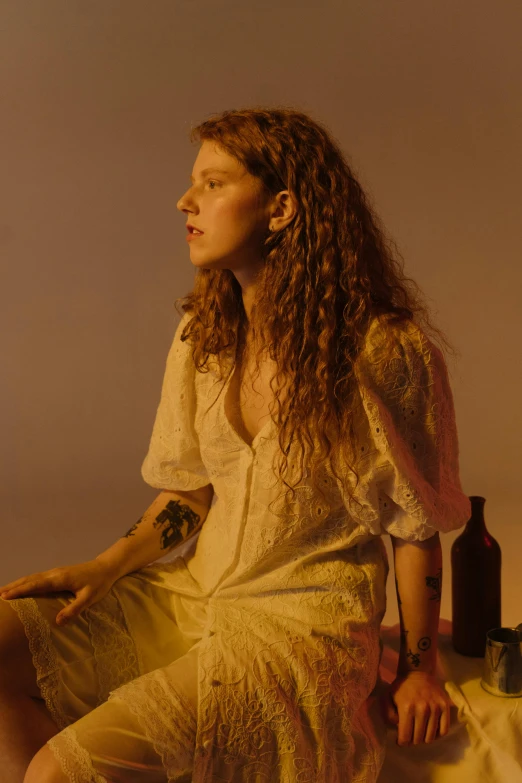 a woman sitting on top of a table next to a bottle