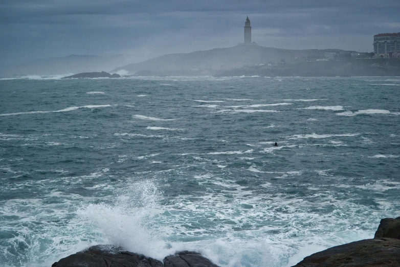 a light house sits behind a distant coast