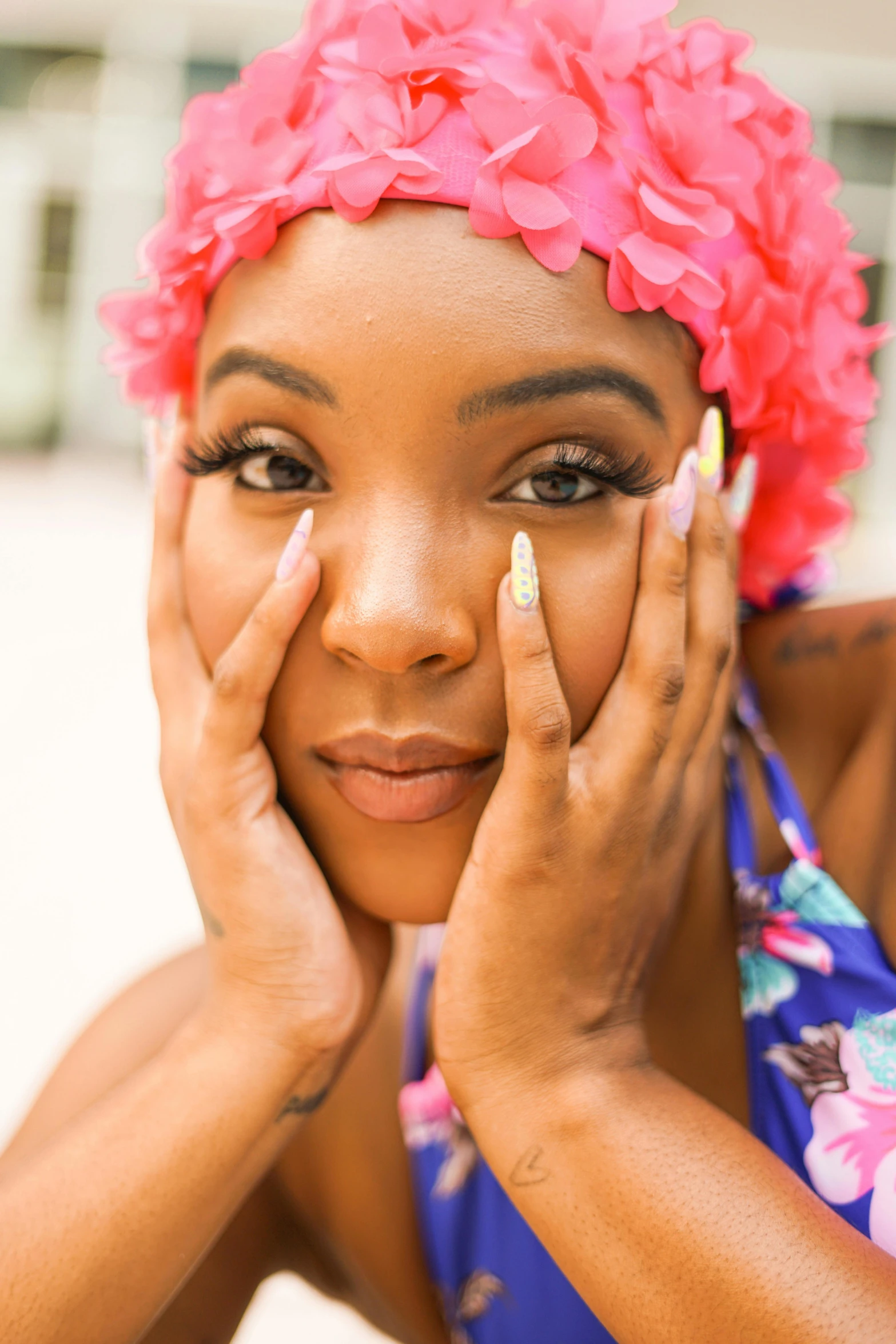 a woman with pink flowers on her head posing for a po