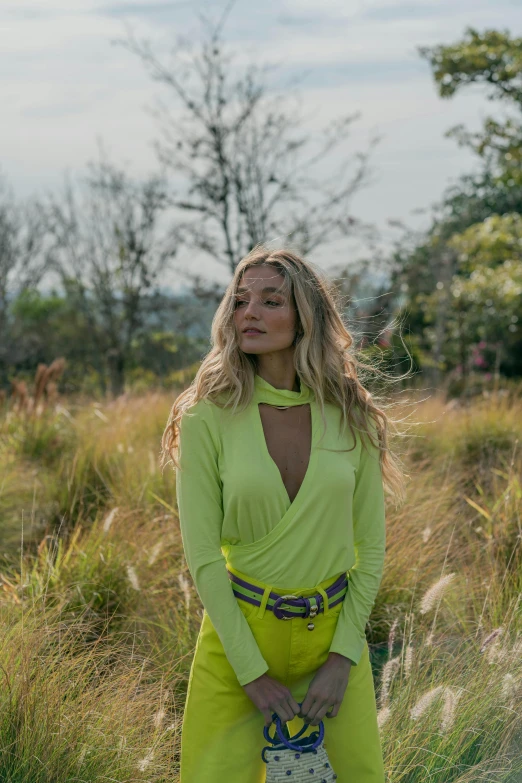 the blonde woman is posing in her yellow outfit