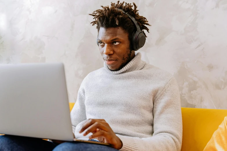 a man with dreadlocks looking at a laptop