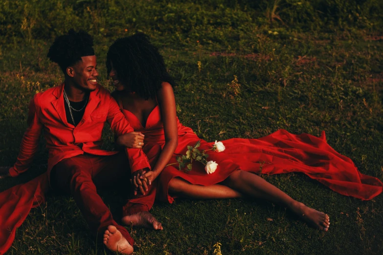 a couple in red sitting on the ground