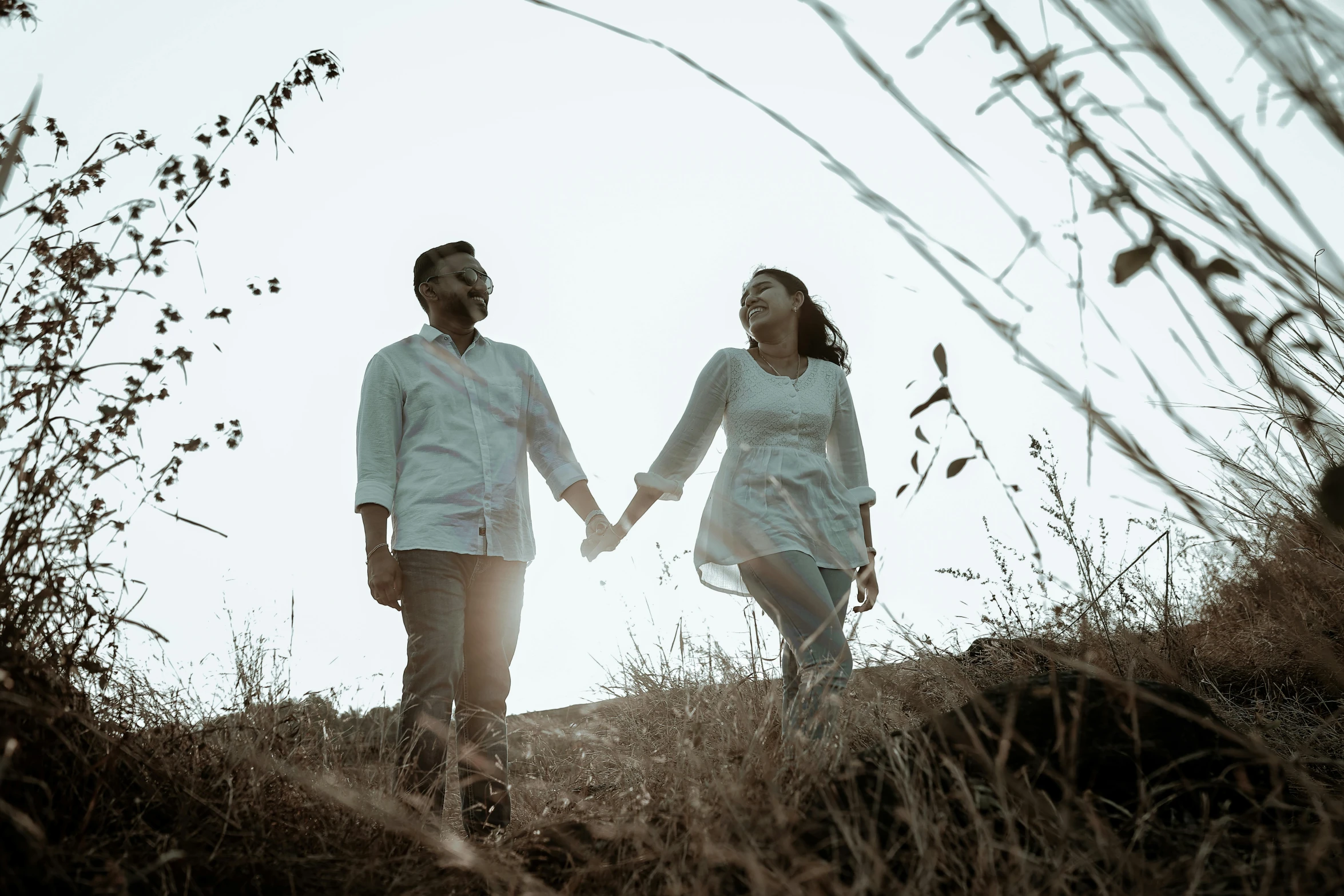 a man and woman walking down a dirt trail together