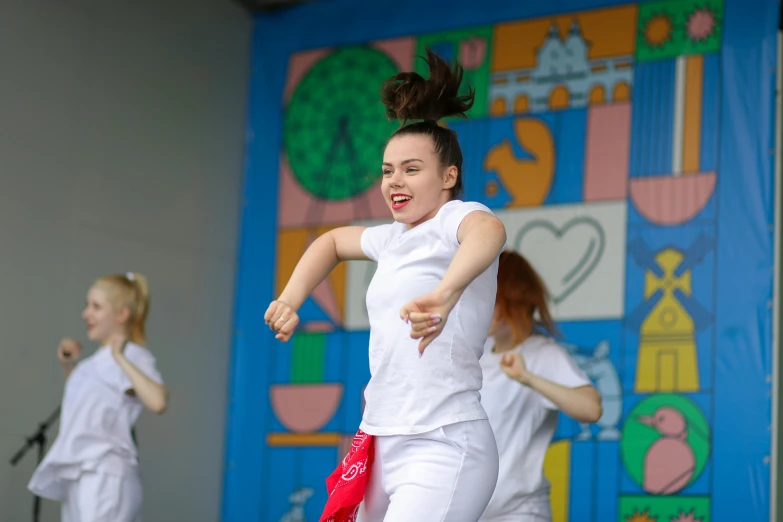 two young ladies dressed in white perform a dance