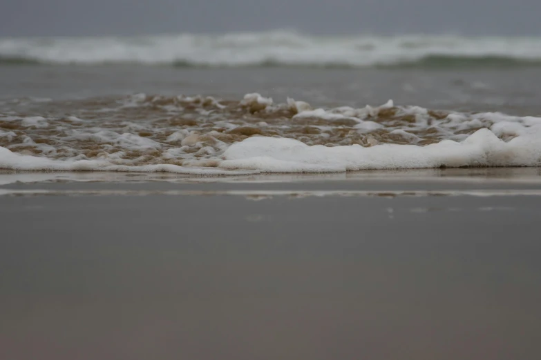 waves roll in on a sandy beach near the ocean