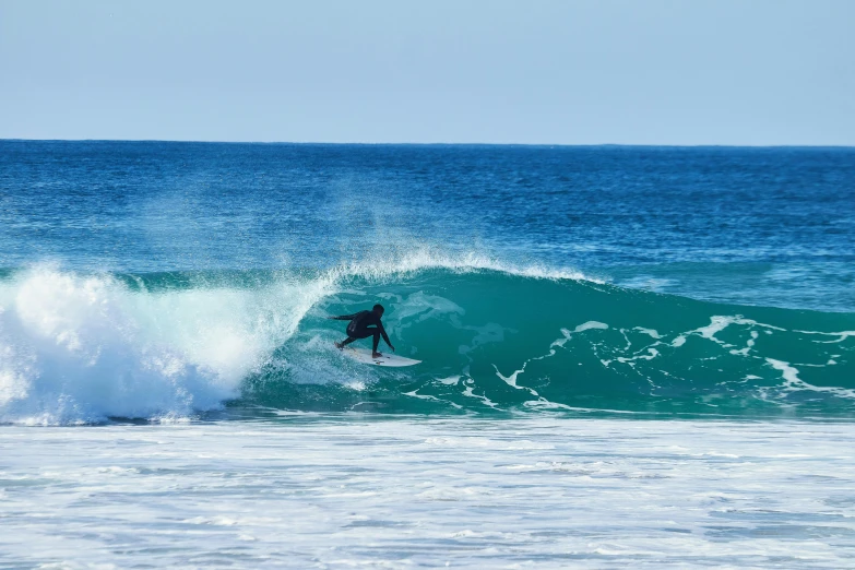 a man riding a wave on top of a surfboard