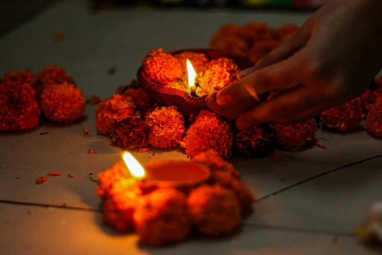 person lighting oil lamps for diwaling