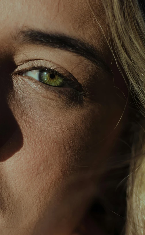 a woman's face is illuminated by the light of a cellphone