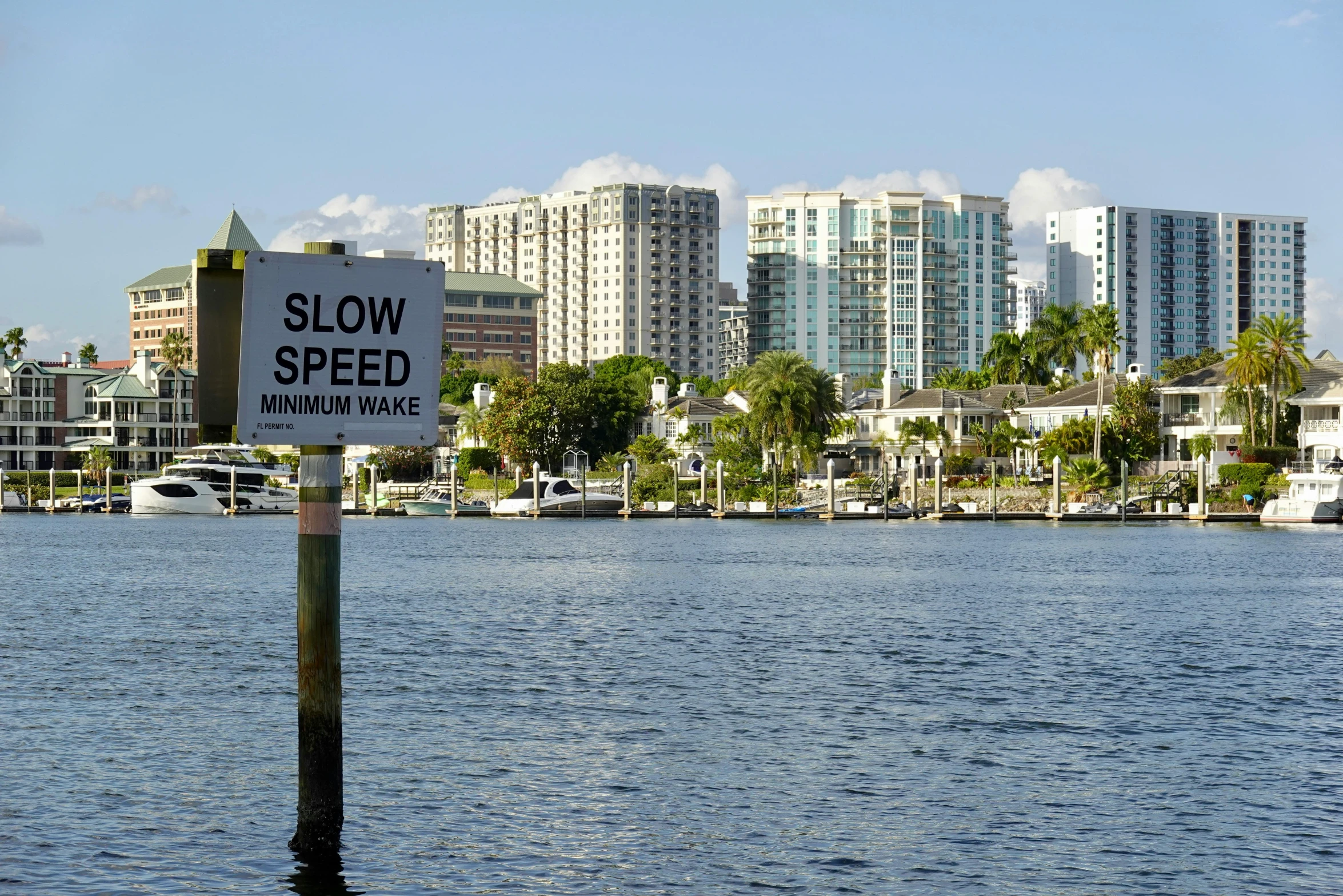 a slow speed warning sign sitting in front of water