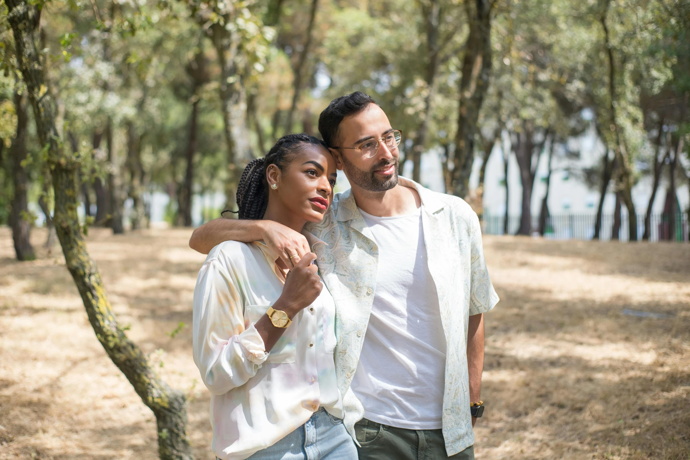 a man and woman are walking in a park