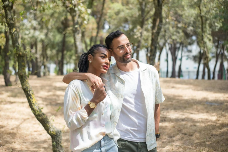 a man and woman are walking in a park