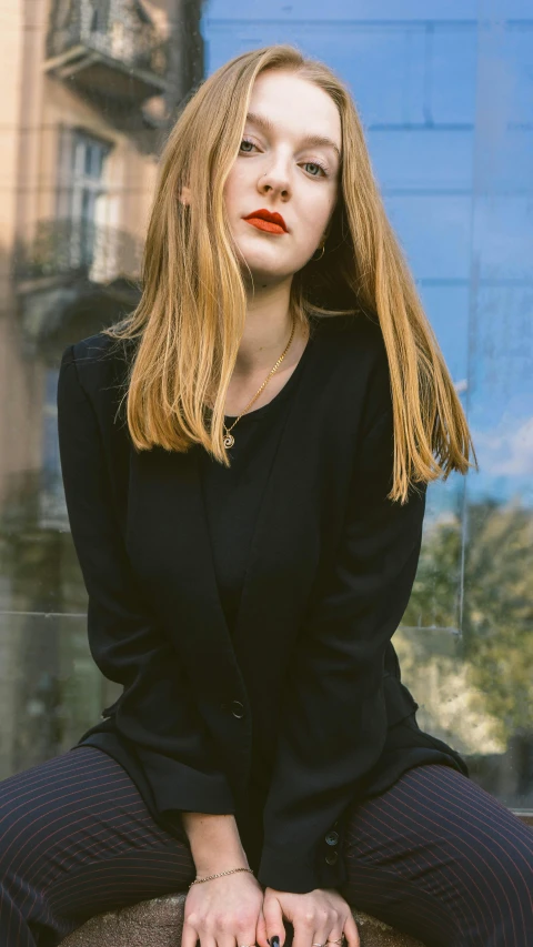 a woman in black sitting down outside