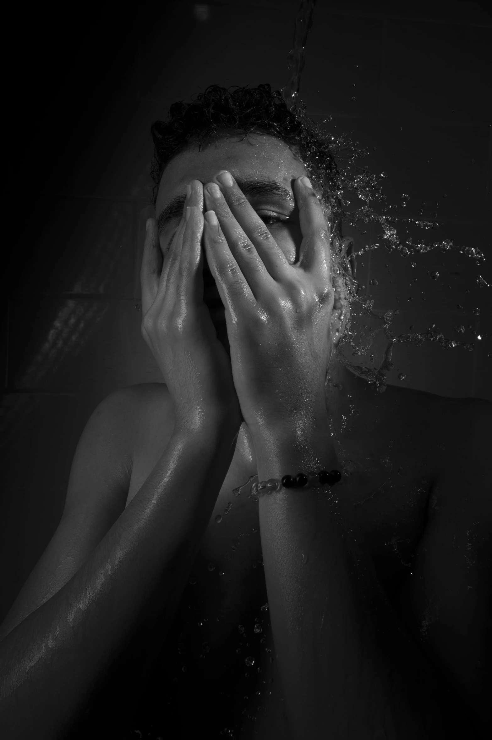 black and white po of a man splashing water in his hands