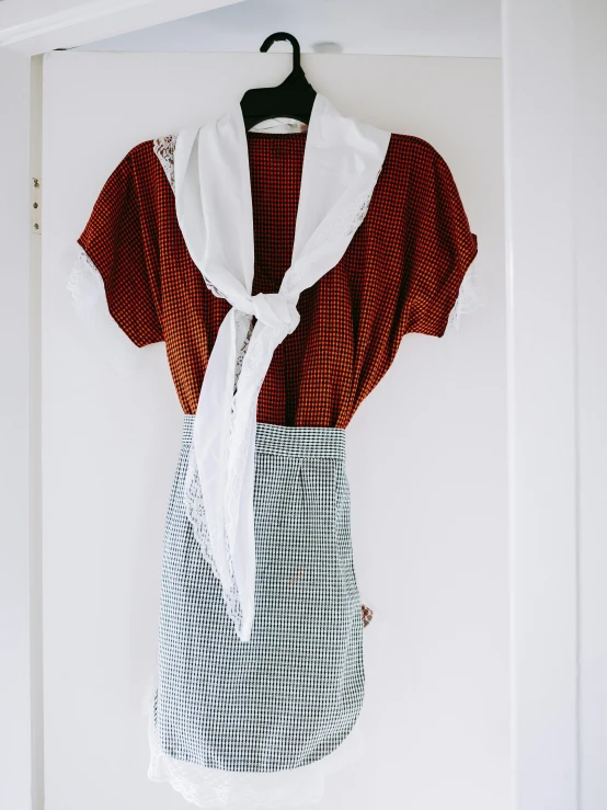 a red and white shirt hanging on a clothes hook