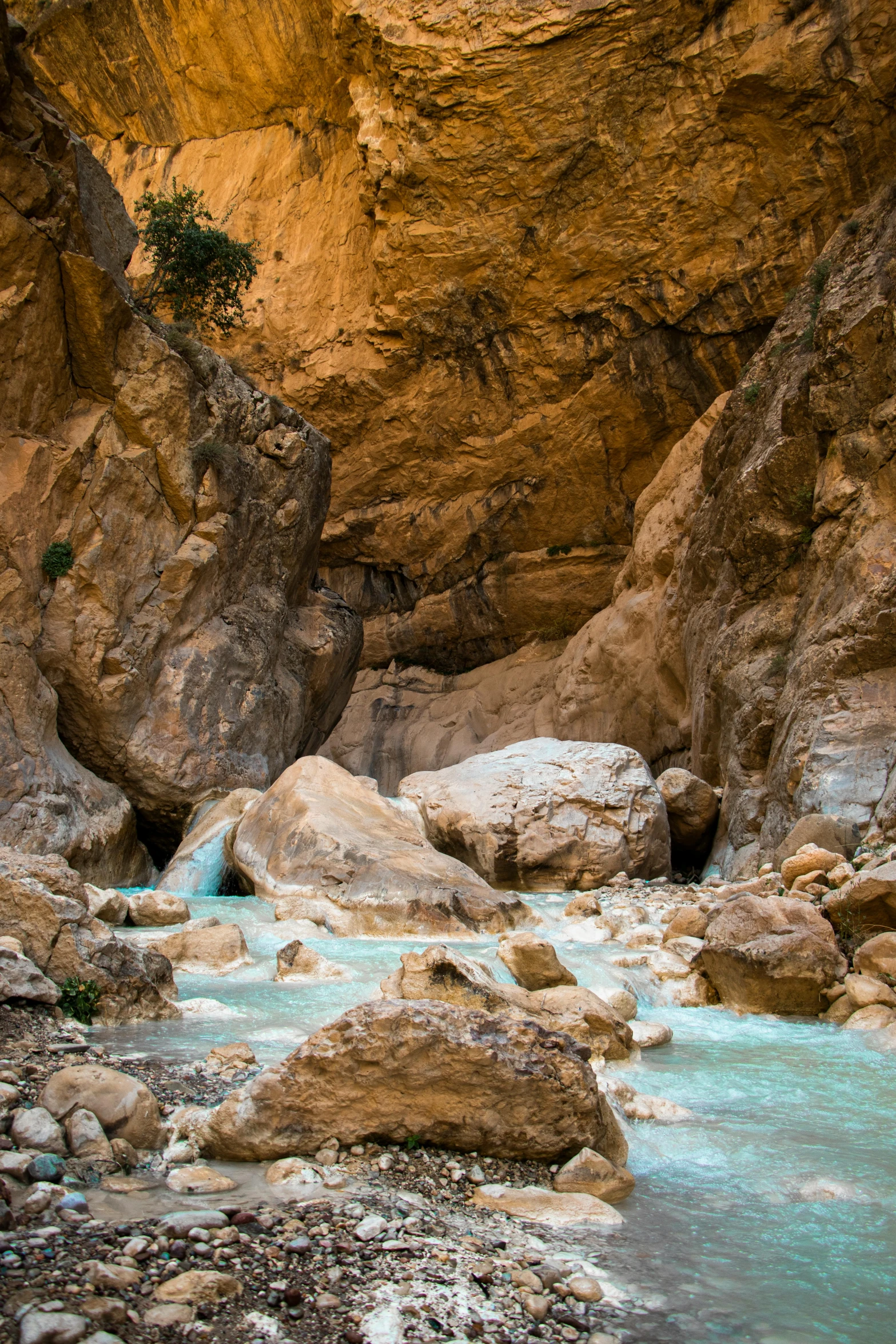 a small stream flowing under a rock bridge