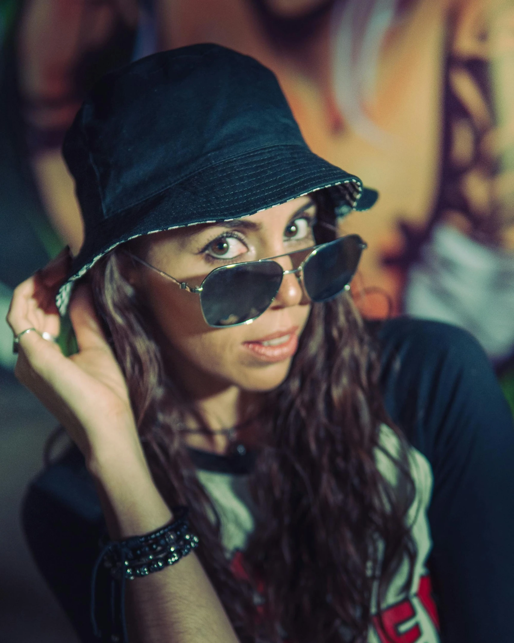 a woman wearing sunglasses and a hat on a cell phone