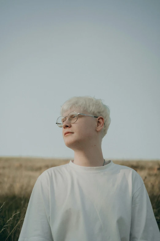 a person in a white shirt standing near tall grass