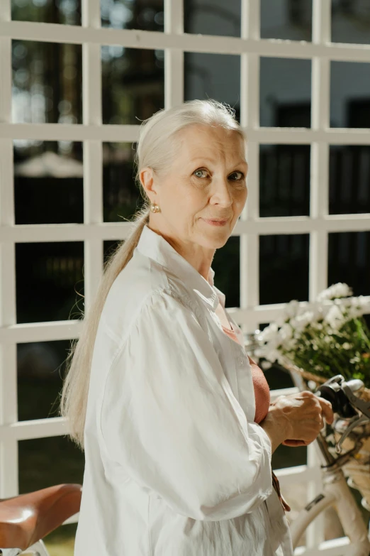 an old woman standing with a bicycle in her hand