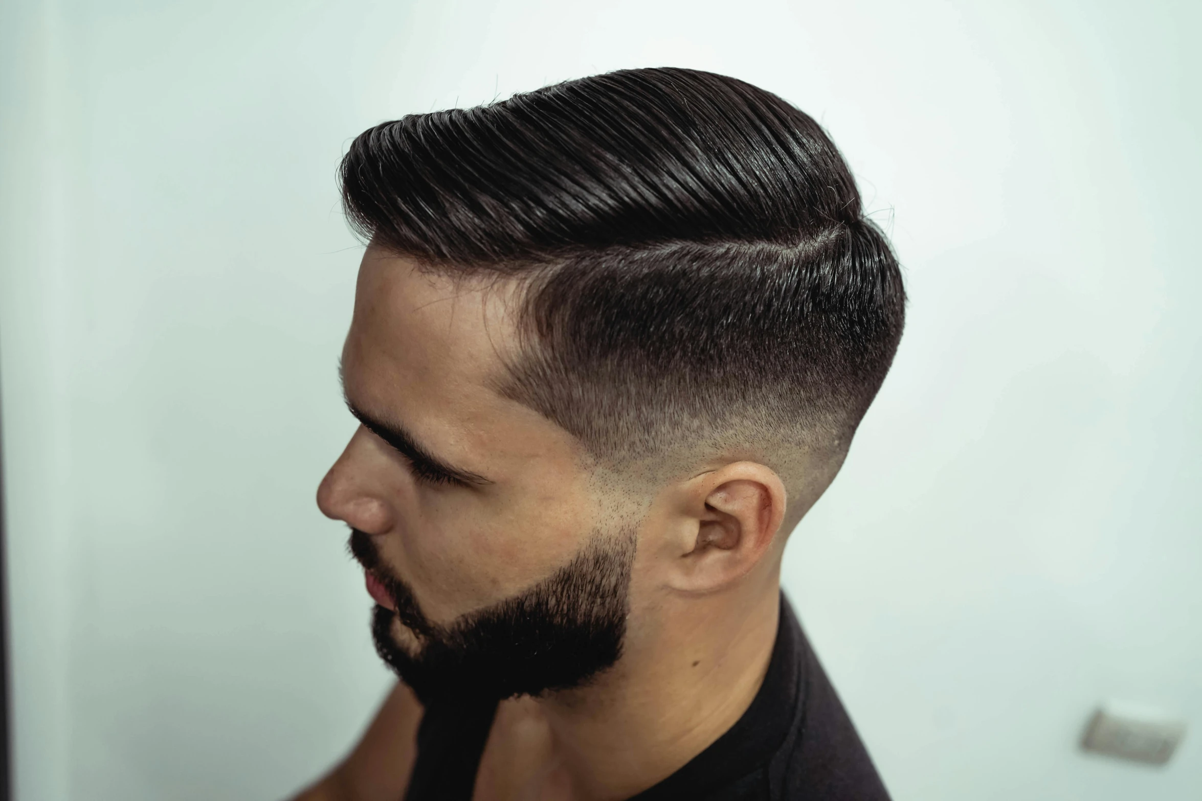 a young man with a long pomp undercut is staring down