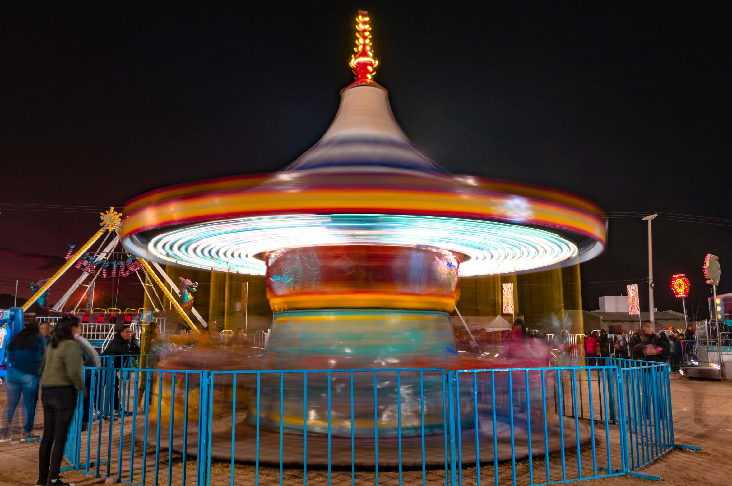 the fairground at night with a carousel at the end