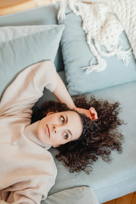 a woman laying on the back of a couch in the living room