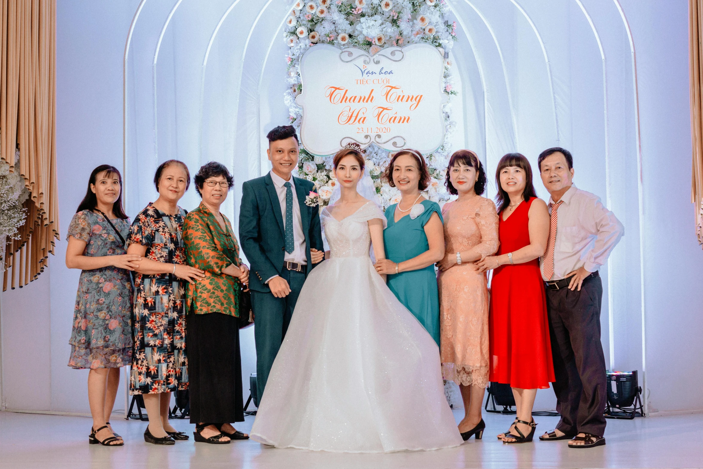 a wedding picture of the bride and groom standing with their family