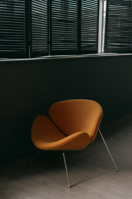an orange chair sitting on a gray floor