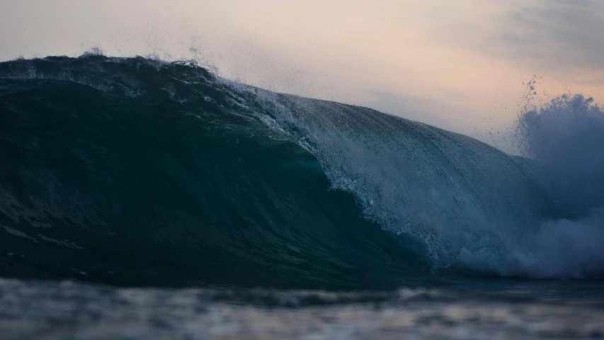 the large ocean wave is breaking over and above the surface