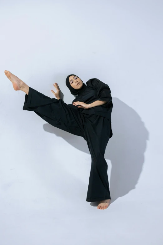 woman in a black outfit posing in a white room