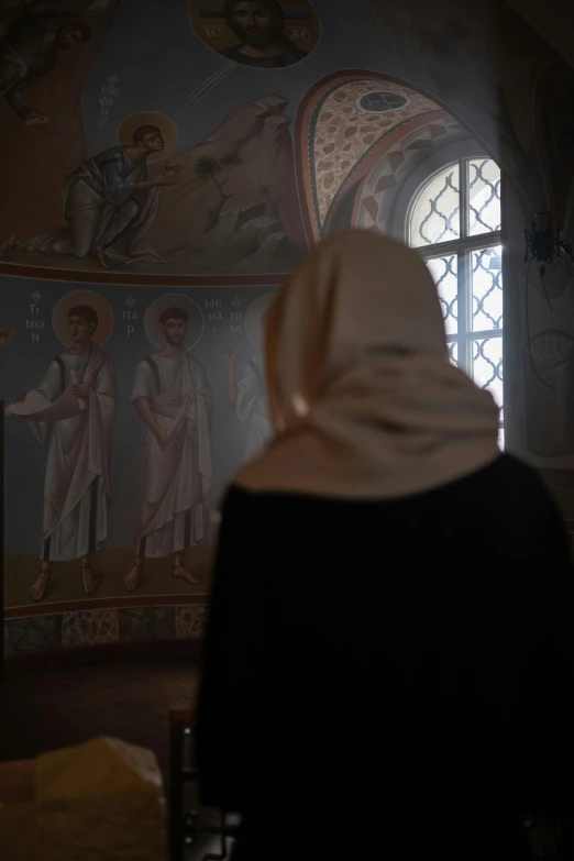 a woman is looking at a painted wall in a room